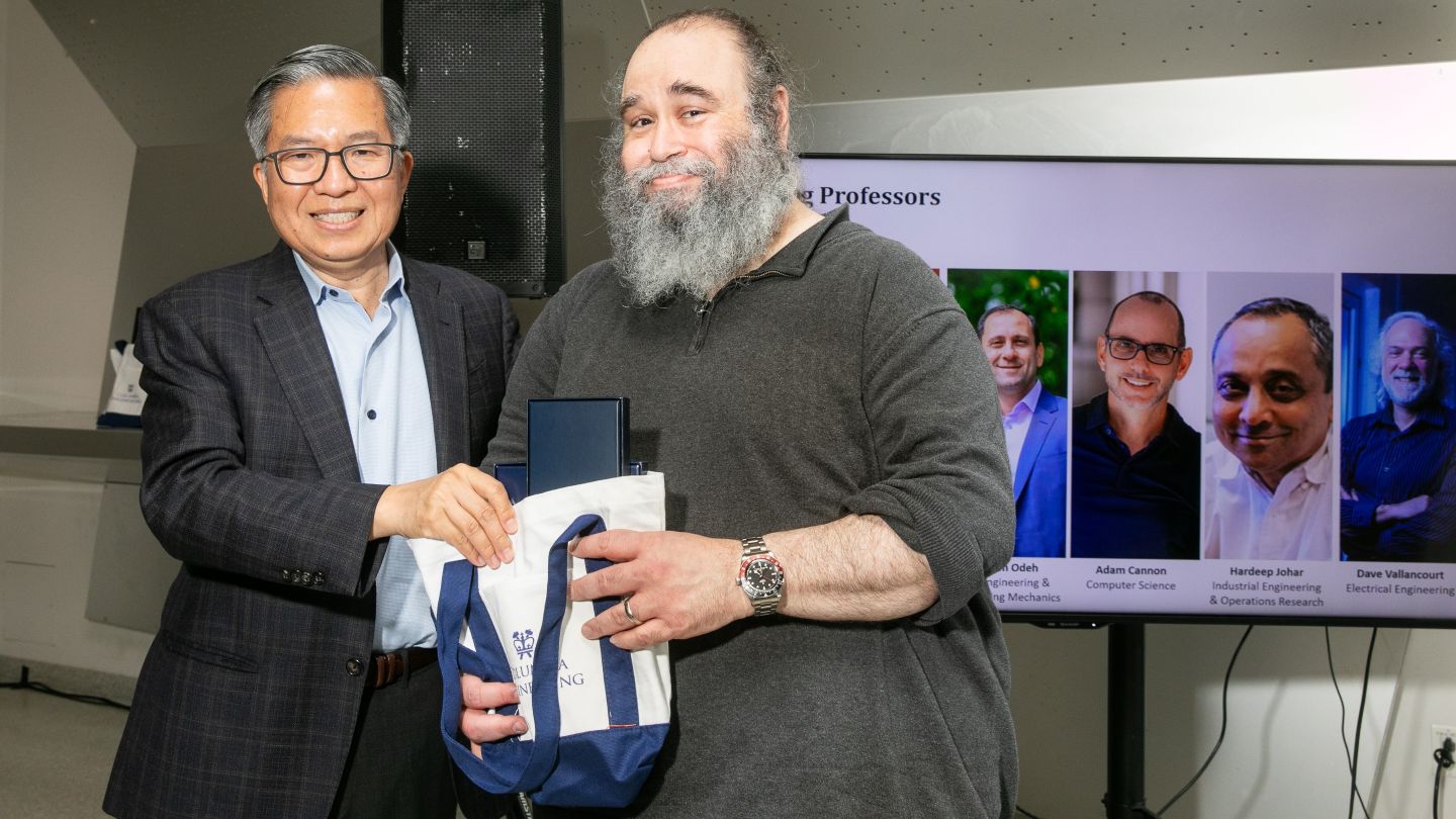 Paul Blaer and Dean Shih-Fu Chang hold a tote bag together.