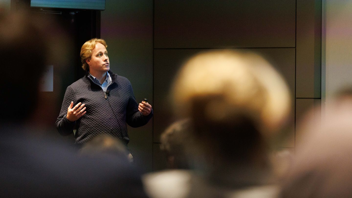 Nathaniel Nichols speaking and gesturing during a presentation to an audience at Columbia Engineering.