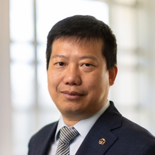 Yan Yao looking at the camera in front of a sunlit window