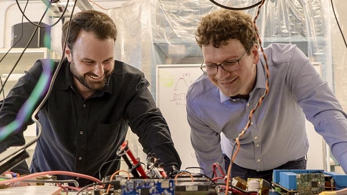 Two researchers next to eachother studying a robotic part