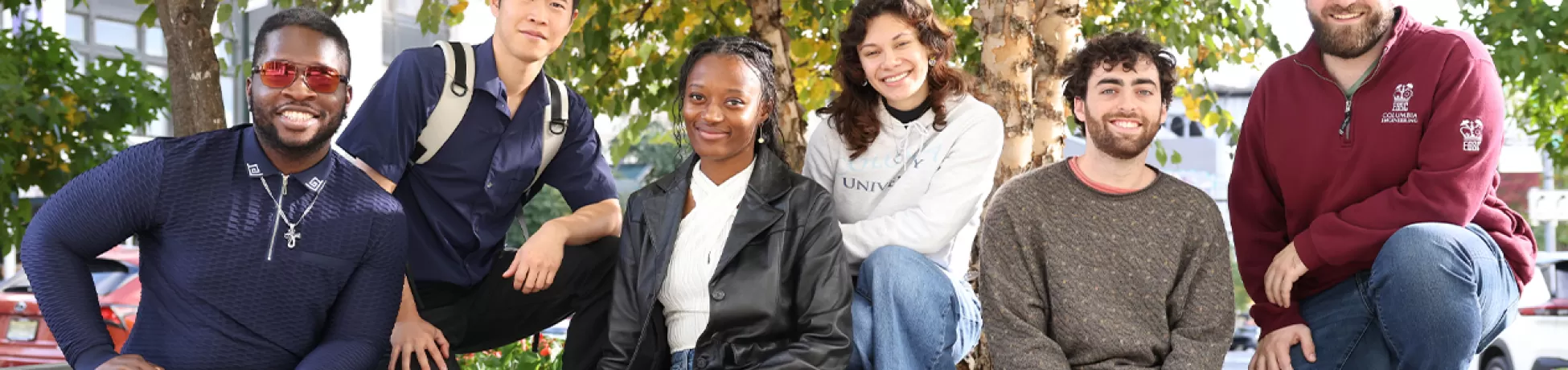 A group of students sitting on a ledge