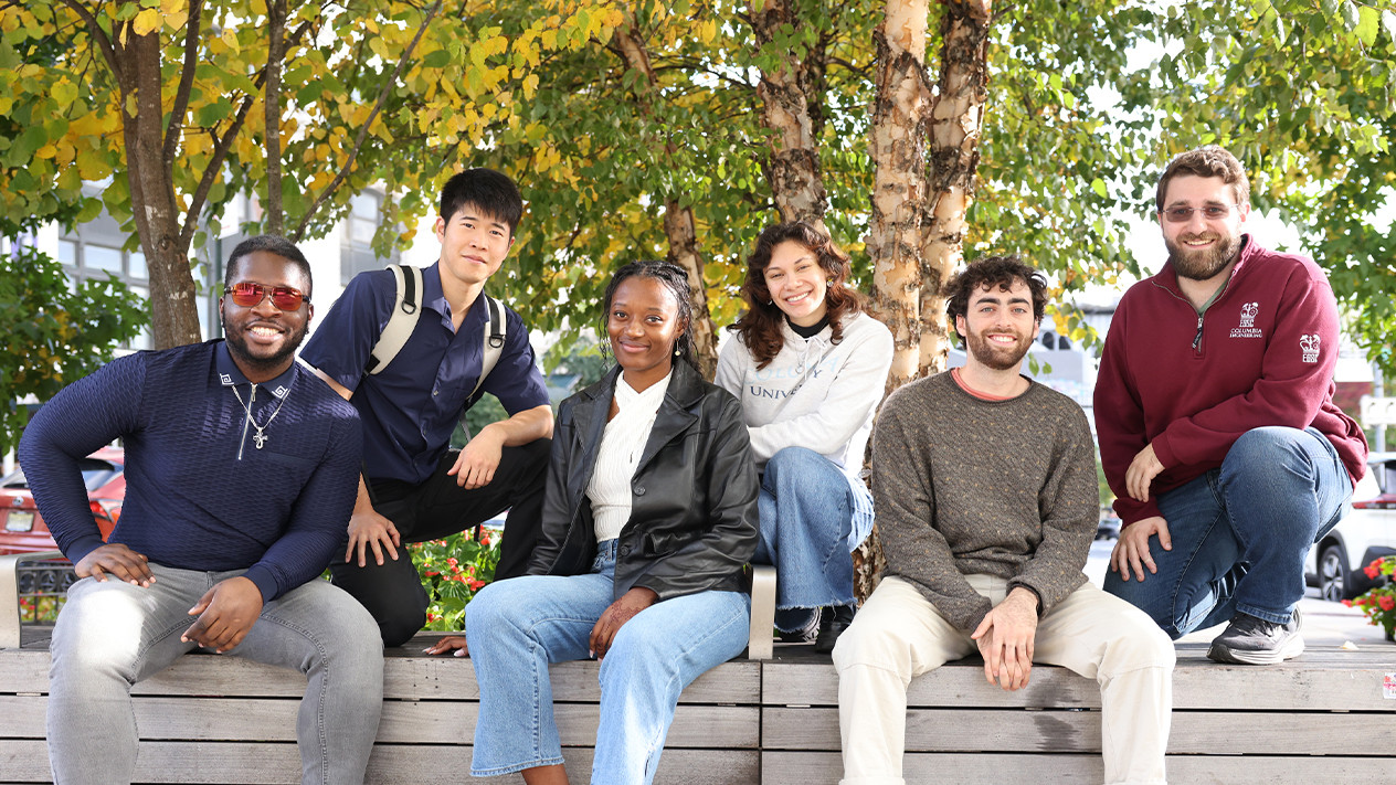 A group of students sitting on a ledge