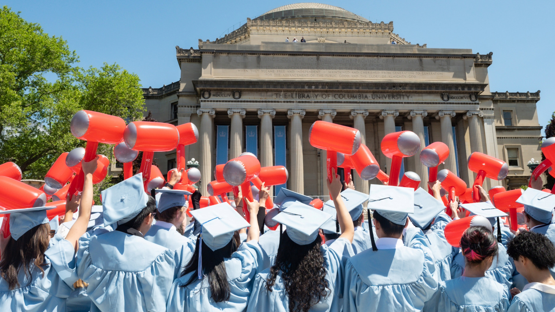Columbia Engineering graduates wave inflatable hammers at Class Day and Commencement outside Butler Library.
