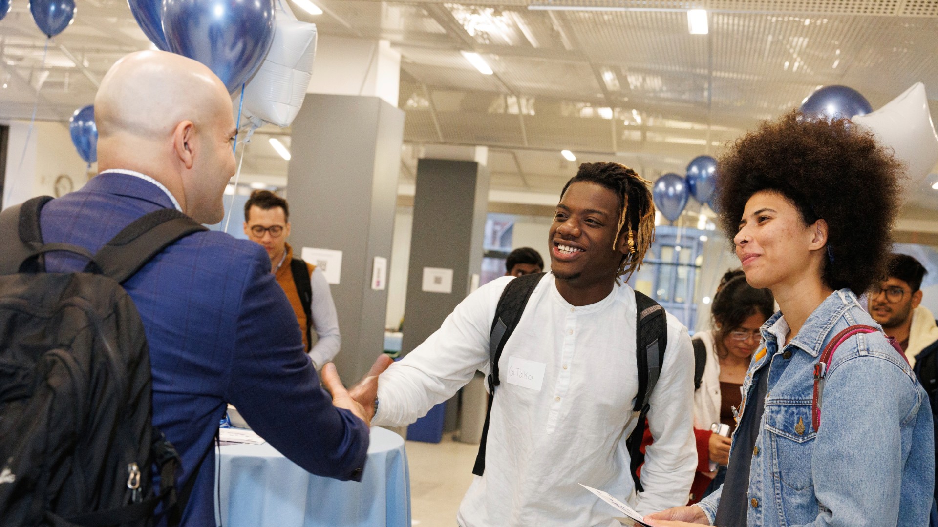 Faculty and students shake hands at a Columbia Engineering event