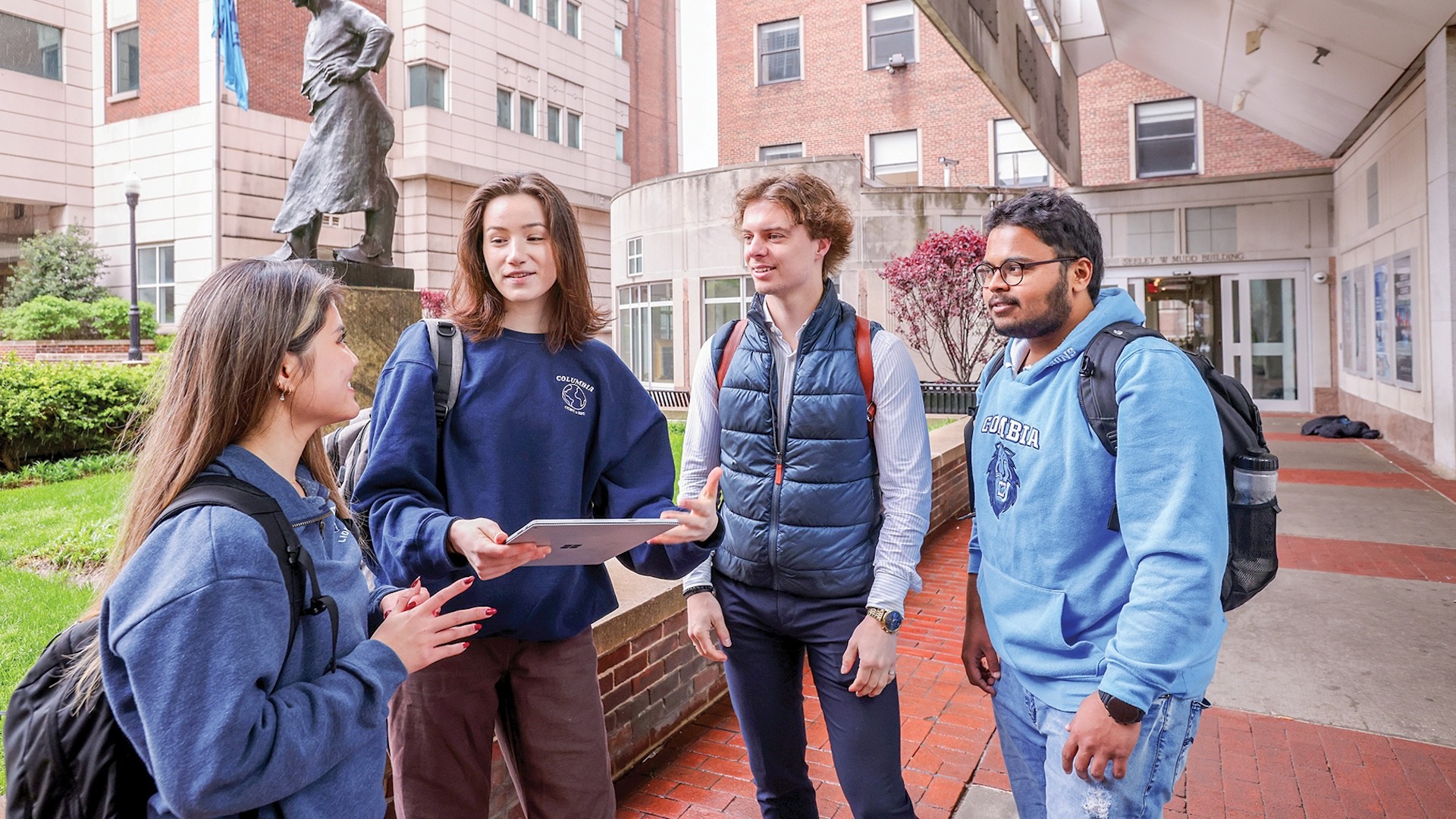 Four students gathered beside Le Marteleur.