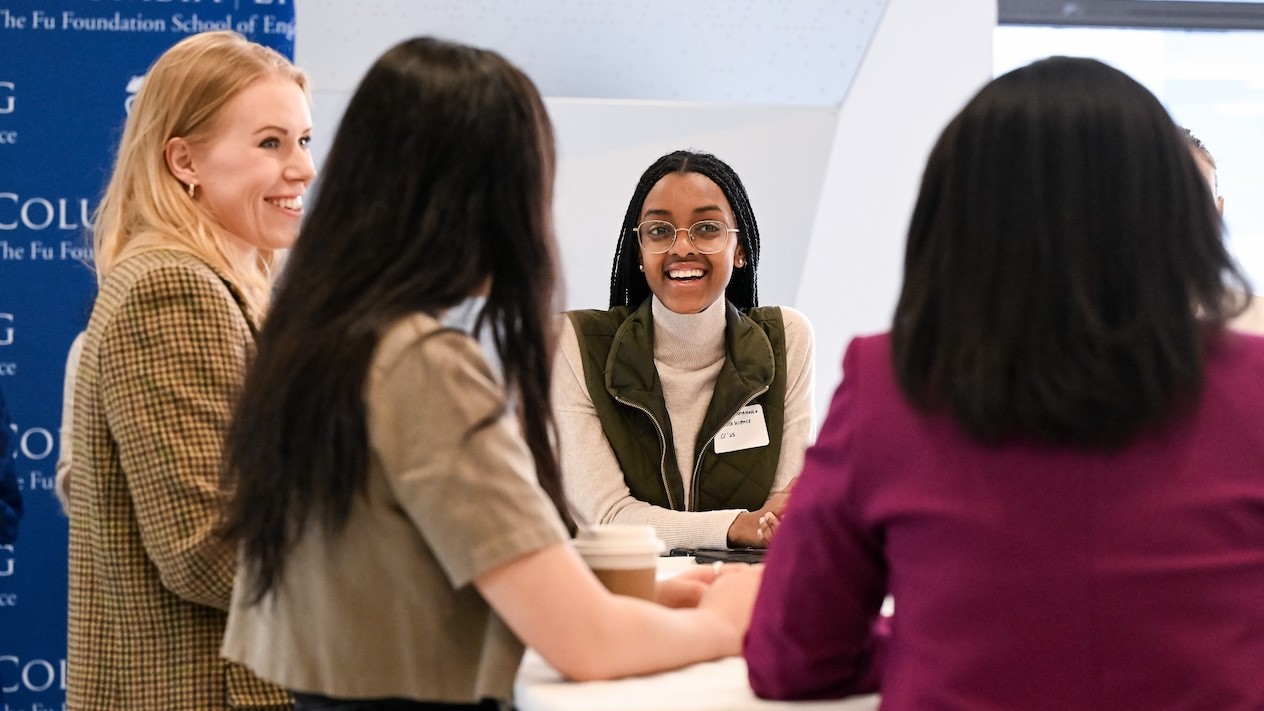 Four women conversing at a table