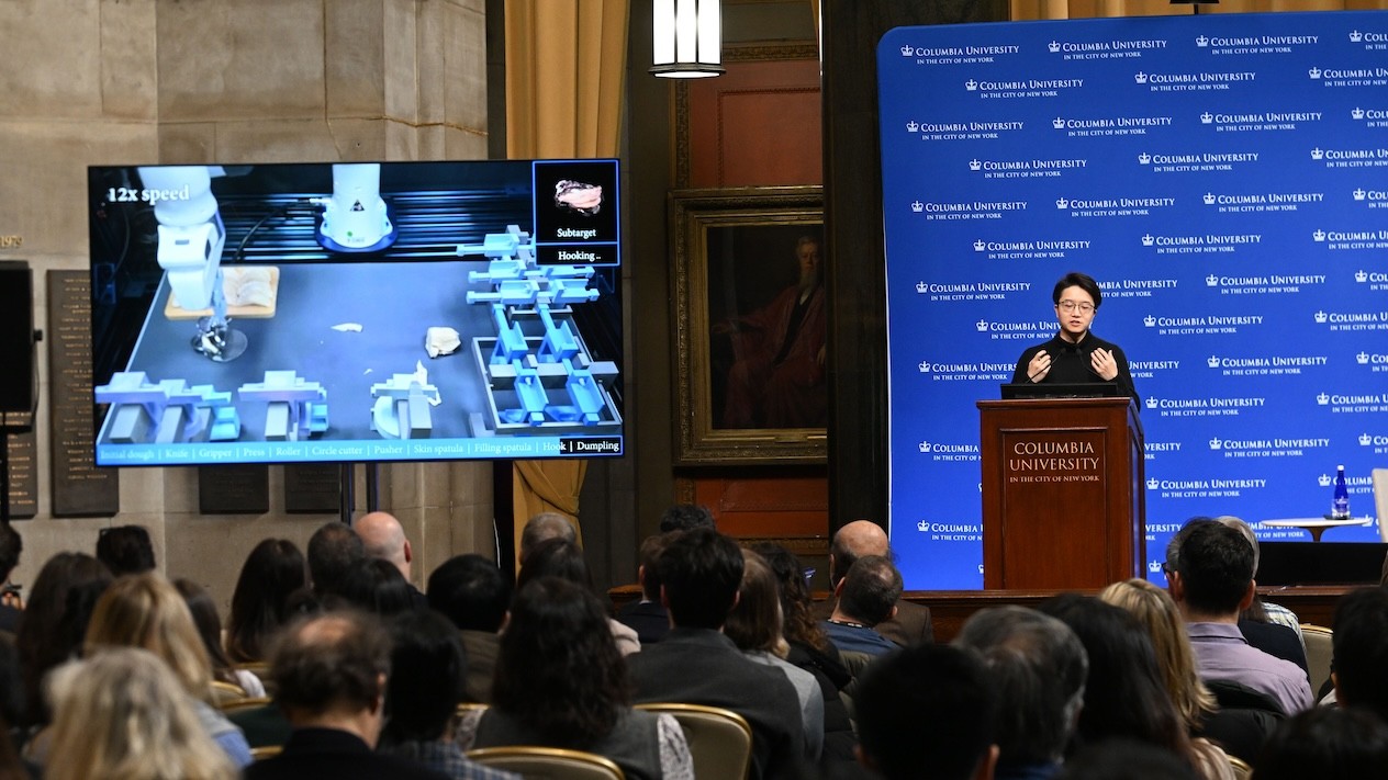 Yunzhu Li, assistant professor of computer science, presents at the Frontiers of AI session to a packed audience in Low Rotunda