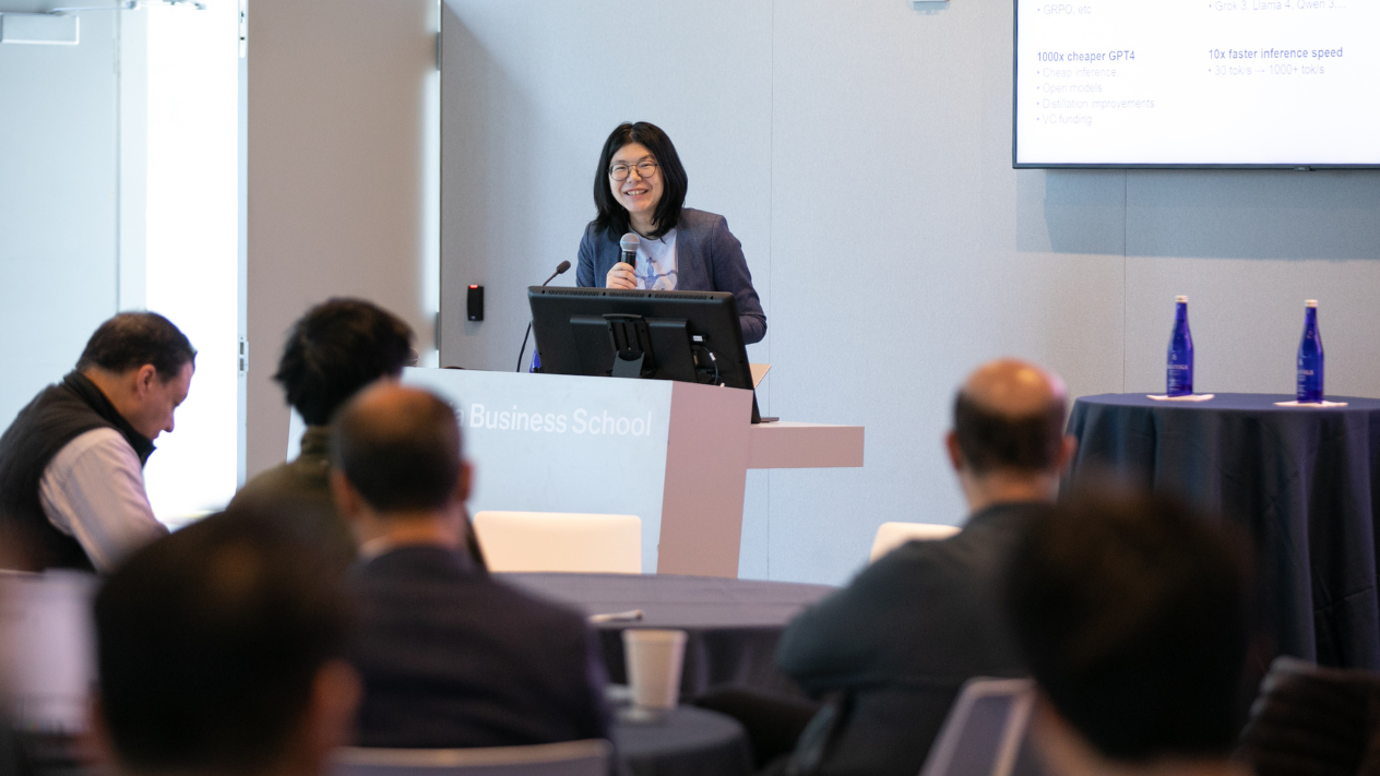 Zhou Yu standing at a podium in front of a crowded room