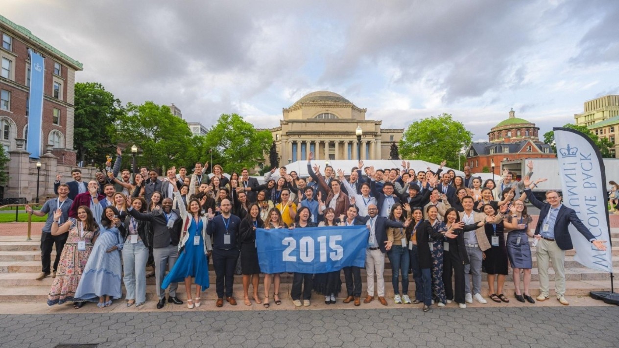Countless Columbia Engineering 2025 reunion attendees posing for a photo with a flag that reads "2015"