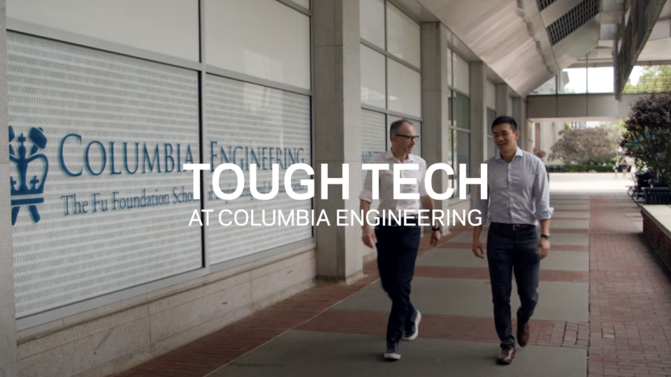 Two men walking in front of a Columbia Engineering logo. 
