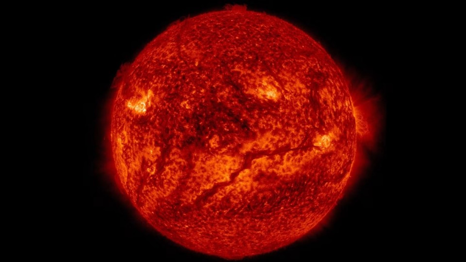 A dark, snaking filament of cooler material stretches across the lower half of the sun’s surface in this Nasa SDO image.