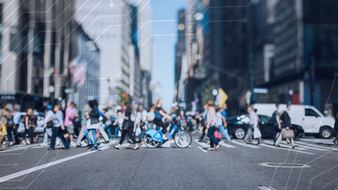 A crosswalk with people walking and bicyclists crossing