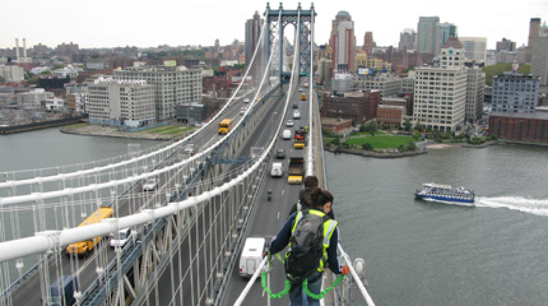Men on the suspension portion of a bridge