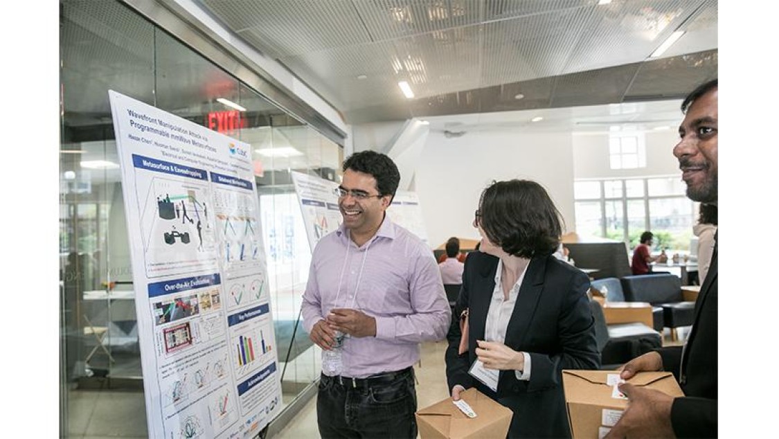 Two people look at a poster.