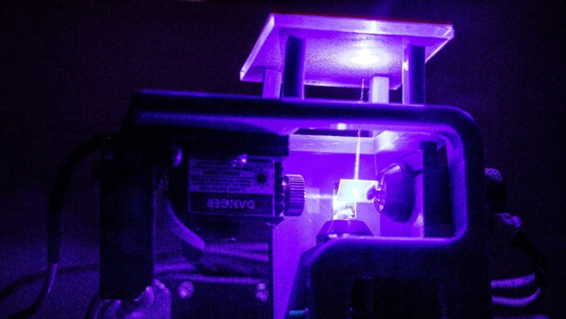 Laser beam transmitting upwards through glass.