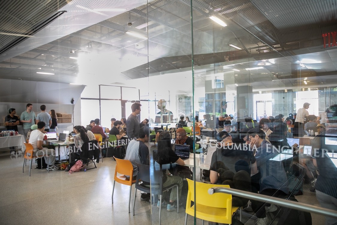 Students participating in the 2024 NYC HAQ hackathon sitting at desks with laptops