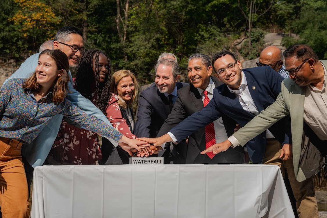 Participants in the Oct. 4 event at Morningside Park gather to ceremonially hit a button to turn the park's waterfall on.