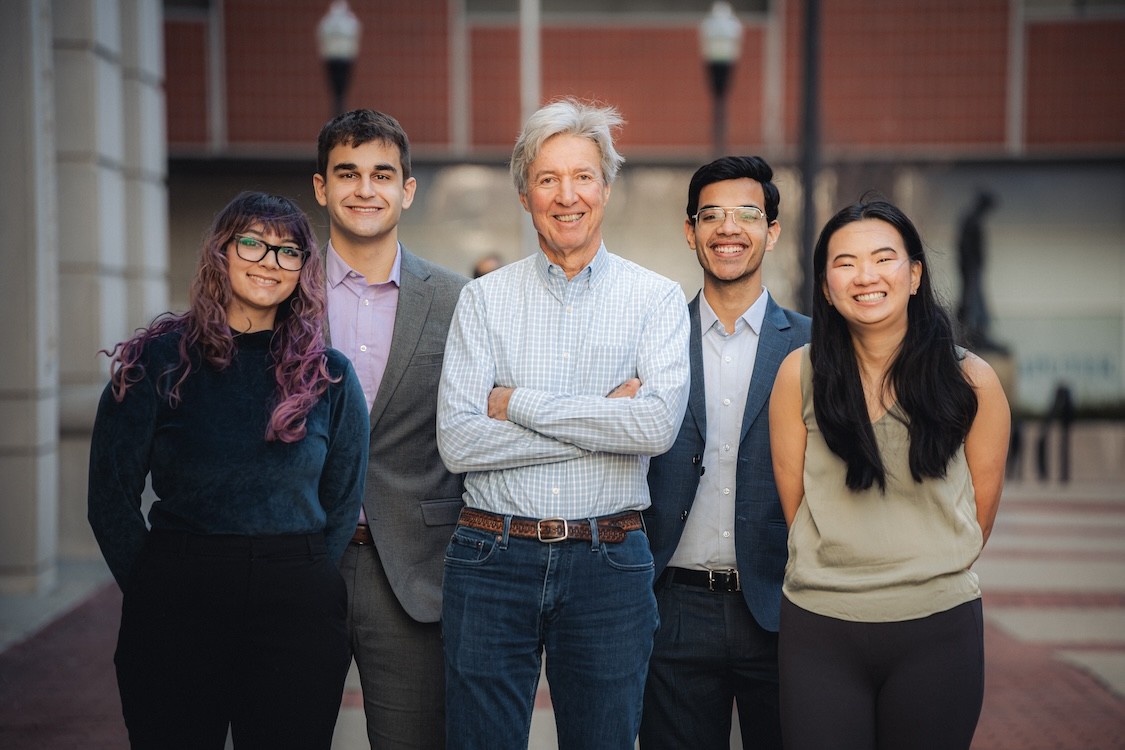 Ralph Izzo poses for a photo with four students outside the Mudd Building