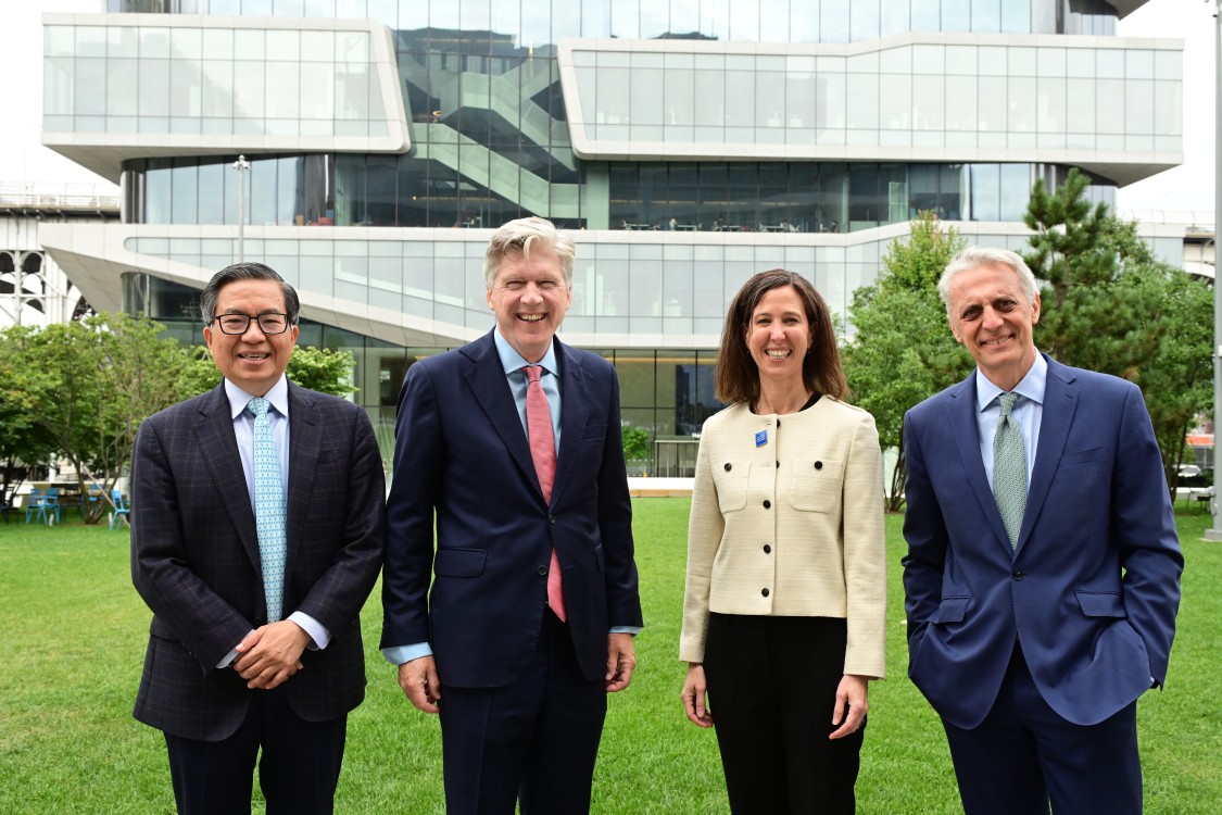 picture of speakers standing in front of glass building