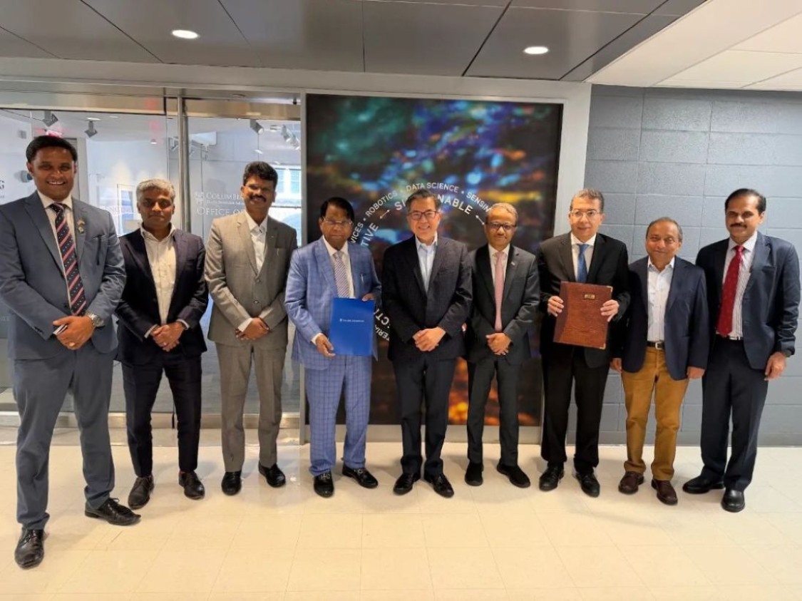 Dean Shih-Fu Chang, Soulaymane Kachani, Hardeep Johar, and other representatives from Columbia Engineering, VIT, and the VIT Alumni Association of North America stand in a curved line in a hallway at a Columbia Engineering building