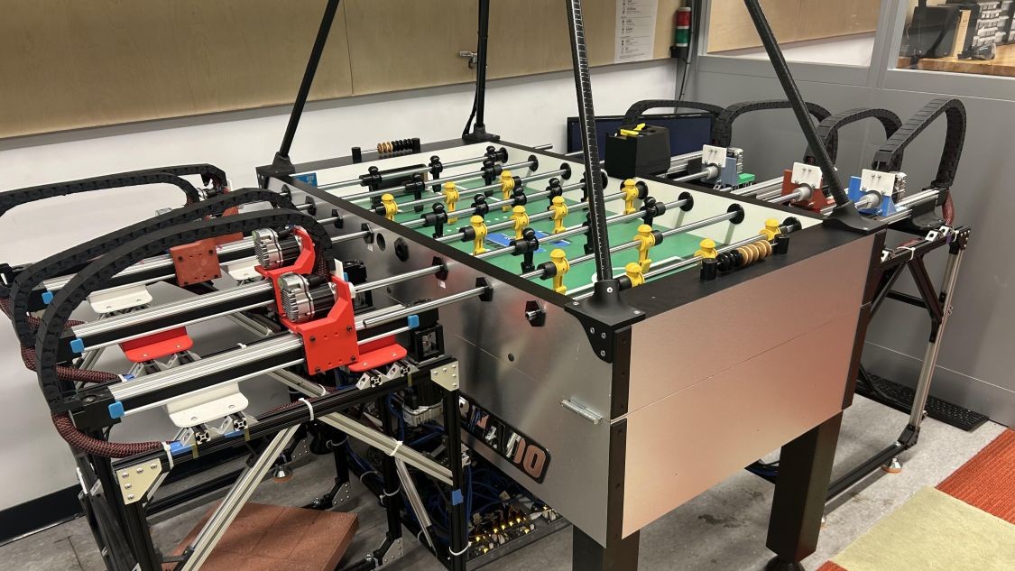 Robotic foosball table equipped with motors, rails, wiring, and automated player controls in a Columbia Engineering lab.