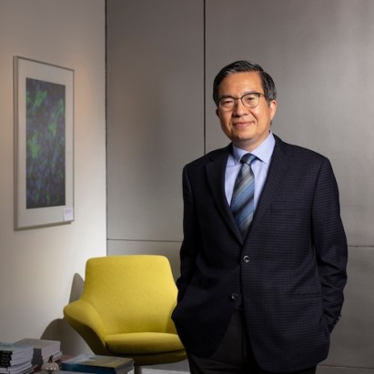 dean shih fu chang standing in front of a yellow arm chair
